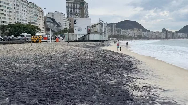 Inea vistoria areia escura na Praia de Copacabana após chuva